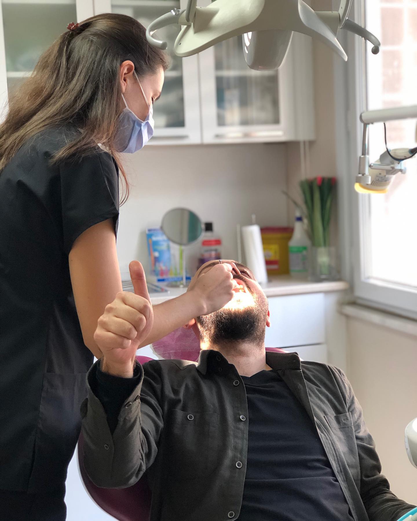 Elis Esen ve klinik koltuğunda başparmağını kaldıran hasta